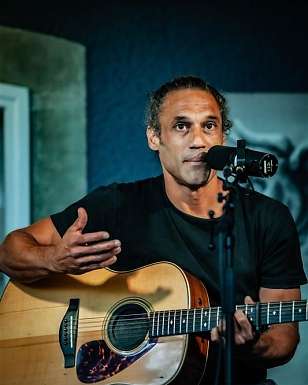 William White singing and playing guitar during an acoustic live performance