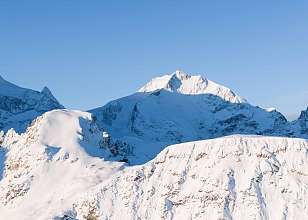 Verschneite Berggipfel im Winter rund um Pontresina bei strahlend blauem Himmel.