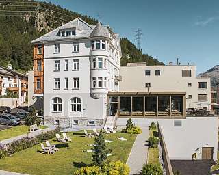 Exterior view of the Sunstar Hotel Pontresina with historic façade, garden area and deck chairs