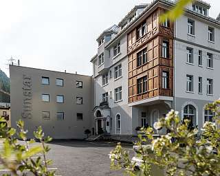 Vue extérieure de l’hôtel Sunstar Pontresina avec façade historique, cour intérieure et plantes au premier plan