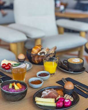 Brunch di Pasqua primaverile con waffle, frutti di bosco freschi, porridge e caffè al Sunstar Hotel Pontresina.